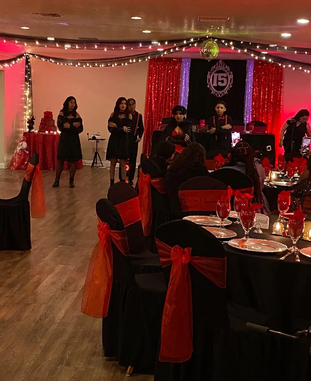 Quinceanera celebration with red and black themed decor and dance floor at Orangecrest Club