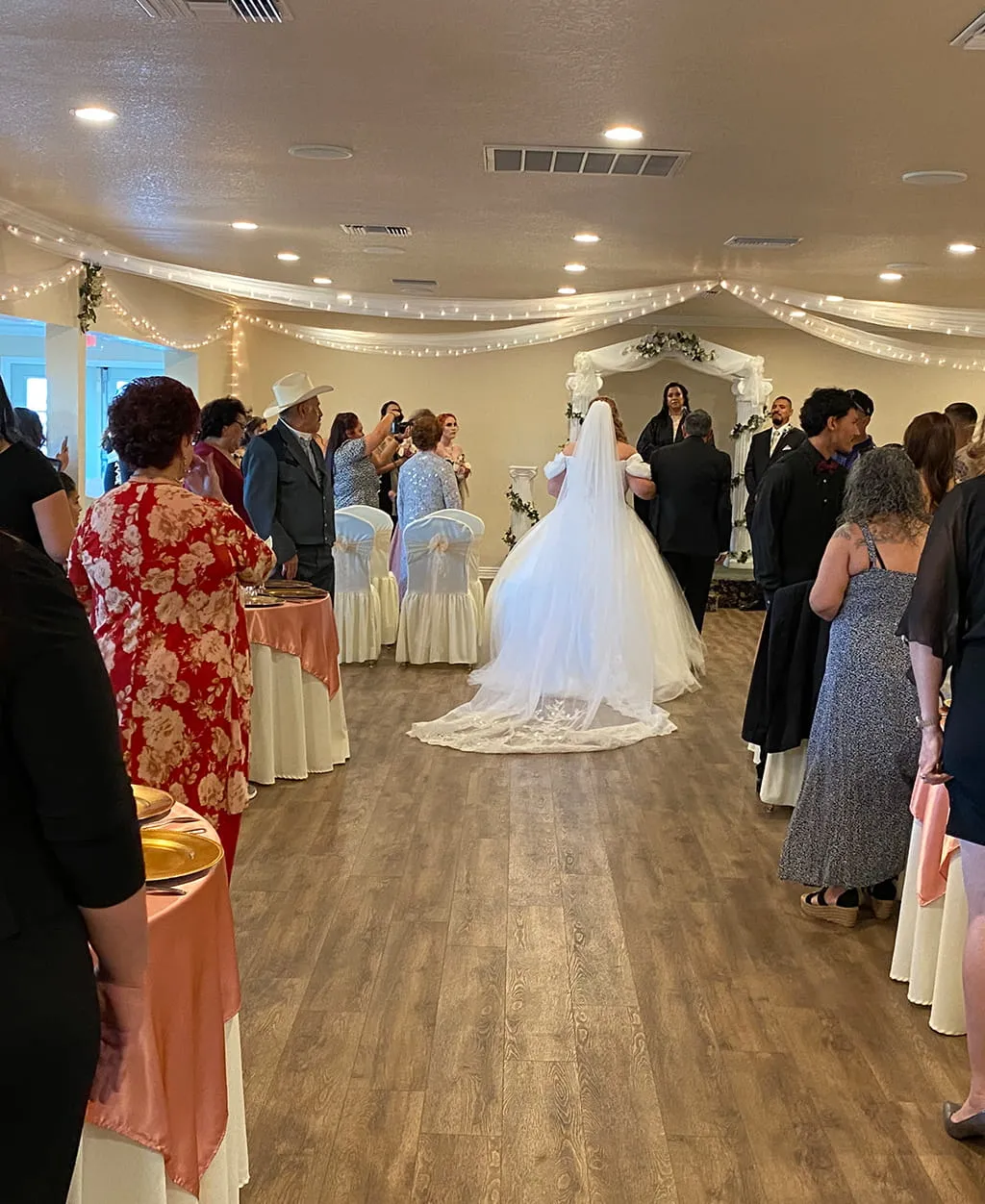 Indoor wedding ceremony with bride walking down aisle at Orangecrest Club