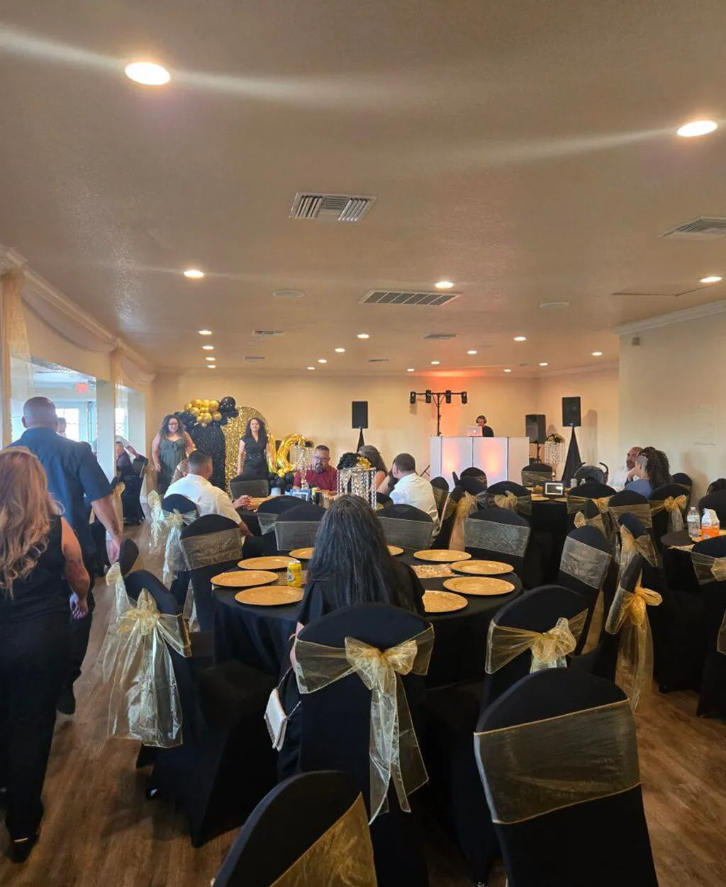 Black and gold themed birthday celebration setup with DJ stage at Orangecrest Club