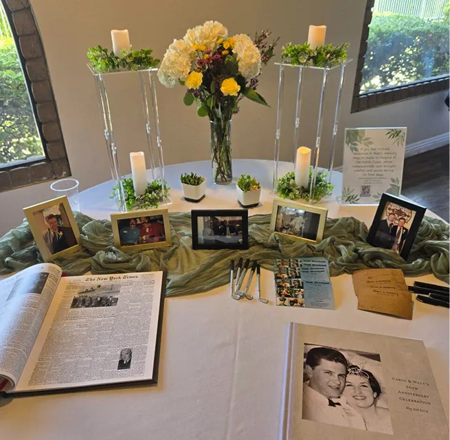Celebration of life memory table with candles, framed photos, and floral centerpiece at Orangecrest Club event venue