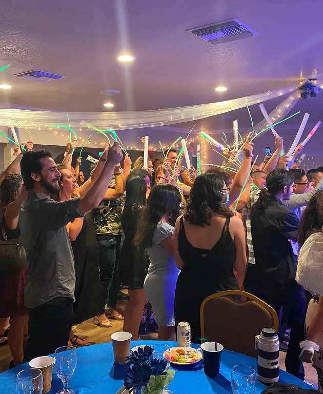 Guests celebrating and dancing with glow sticks at a lively private party event inside Orangecrest Club venue