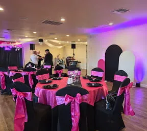 Party event setup with pink and black table decor and stage lighting at Orangecrest Club venue