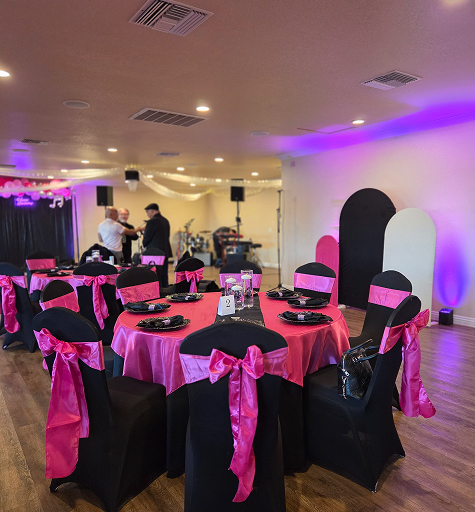 Pink and black themed party table setup with decorated chairs and dance floor at Orangecrest Club venue