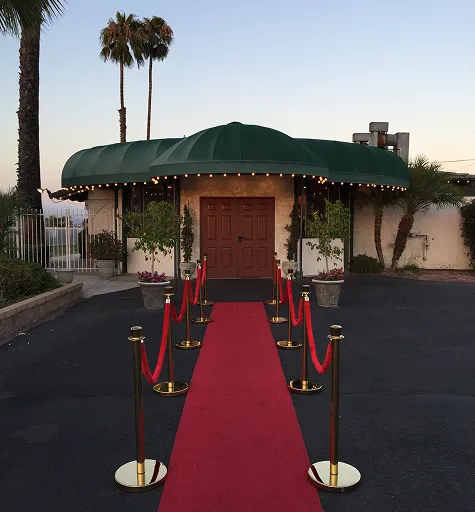 Red carpet entrance setup with stanchions leading to Orangecrest Club private event venue building