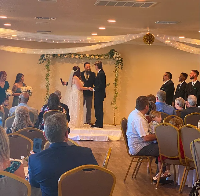 Bride and groom exchanging vows during an indoor wedding ceremony at Orangecrest Club event venue